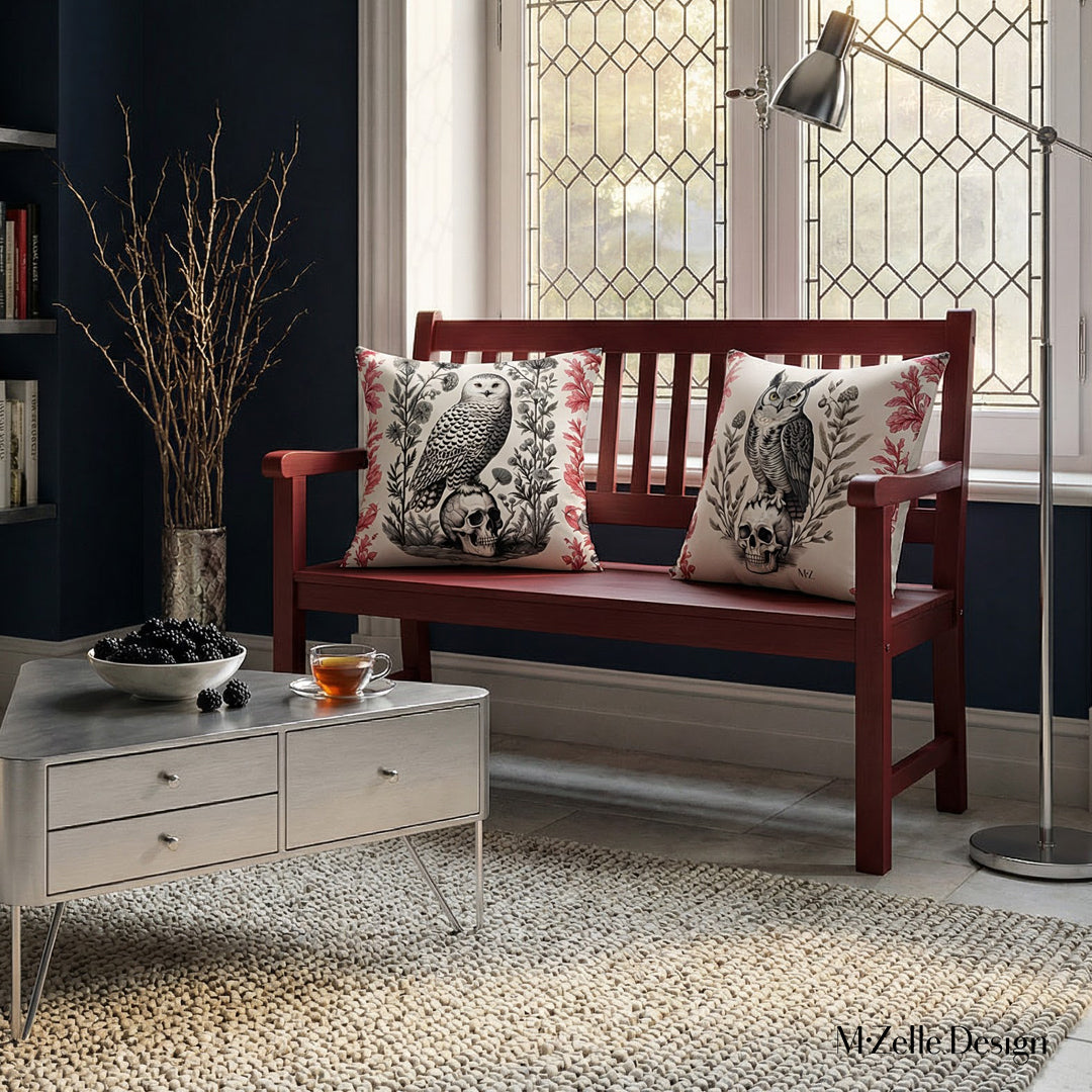 Photographie professionnelle d'un loft inspiré de l'esthétique gothique mélangée à un design contemporain, avec un banc en bois rouge foncé orné au centre de 2 coussins motif hibou et chouette crâne vanité, table triangulaire.