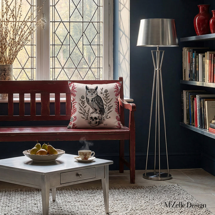 Photographie professionnelle d'un loft inspiré de l'esthétique gothique mélangée à un design contemporain, avec un banc en bois rouge foncé orné au centre d'un coussin motif hibou  crâne vanité, table triangulaire.