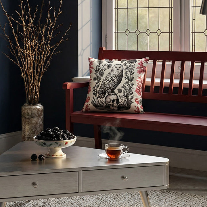 Photographie professionnelle d'un loft inspiré de l'esthétique gothique mélangée à un design contemporain, avec un banc en bois rouge foncé orné au centre d'un coussin motif chouette crâne vanité, table triangulaire.