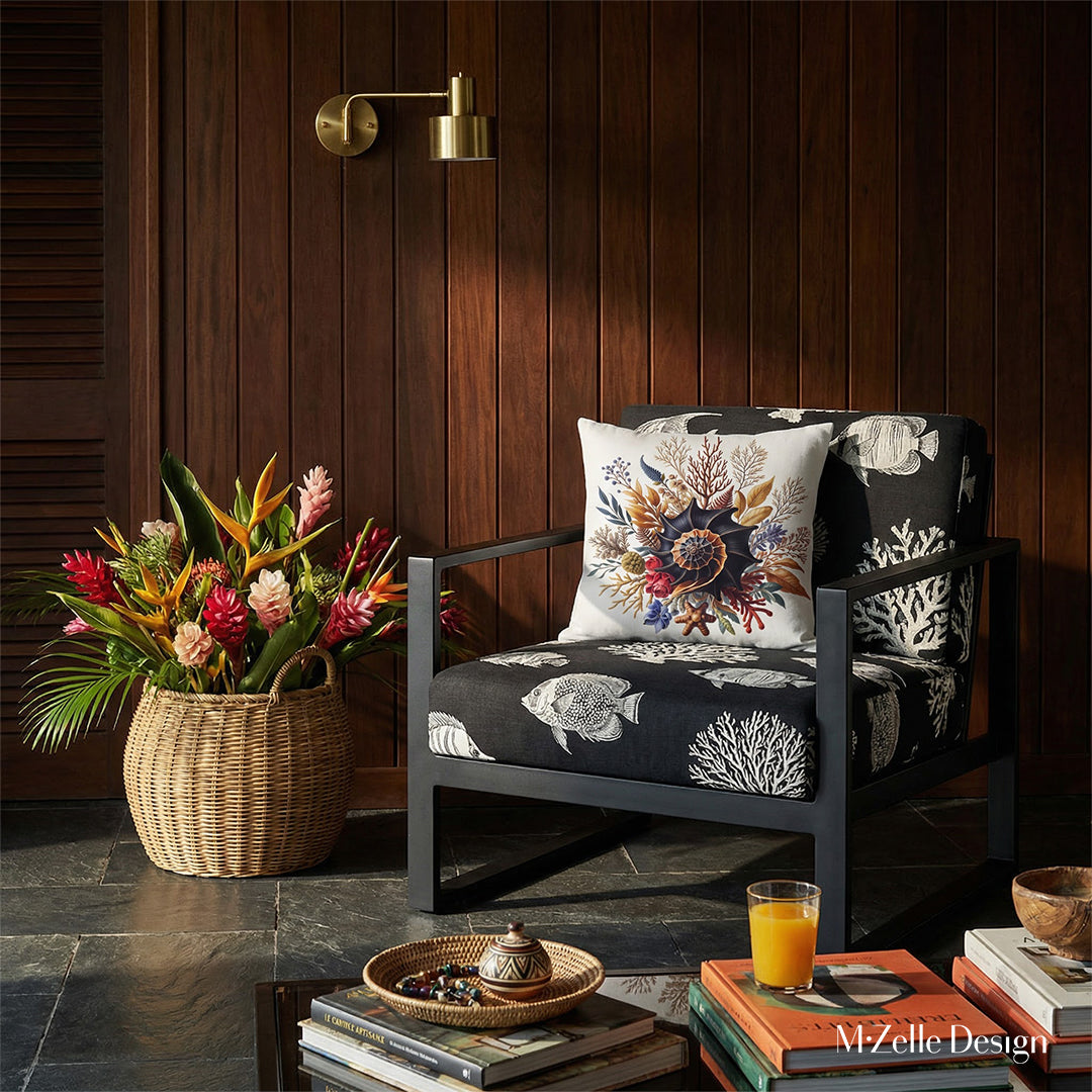 Photographie intérieure de style éditorial d’une villa créole d'architecte, vue de face d'un fauteuil épuré structure épaisse en métal noir avec des motif blanc représentant des poissons tropicaux et des coraux, orné d'un coussin carré motif coquillage, placé contre un mur de panneaux de bois sombre.