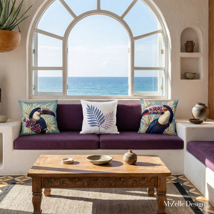 Photo professionnelle hautement détaillée, salon Arty dans une villa cubaine baignée de soleil avec murs blanchis à la chaux, fenêtre en demi-lune vue mer et canapé intégré dans le mur en dessous, assises violet foncé avec un coussin motif toucan de chaque côté.