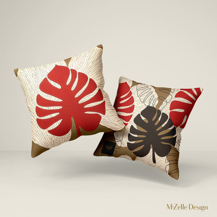 Deux Coussins d'ambiance Mzelle Design aspect Lin imprimé avec des Monsteras Deliciosa enlacées sur fond de composition graphique, écru, rouge et marron cacao.