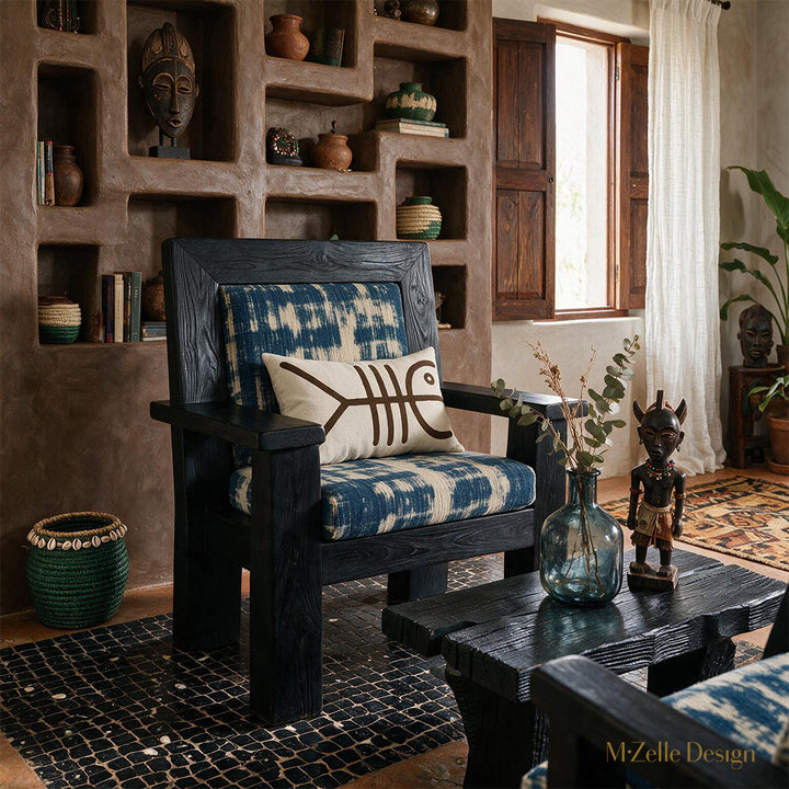 Photo professionnelle lifestyle, décoration Salon ethno-créole haut de gamme, chaise au design audacieux vue de face,  ornée d'un coussin mzelle design . Table basse en bois brûlé noir garni d'un vase en verre fumé bleu et d'une statuette style vaudou artistique. 