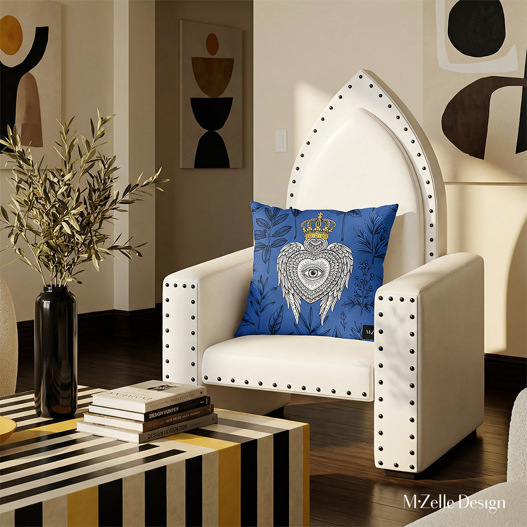 Photographie professionnelle représentant le design intérieur haut de gamme d'un salon lumineux. Vue de face d'un grand fauteuil blanc aux rivets noirs, orné d'un grand coussin carré motif ex voto au milieu et de deux coussins blancs et noirs aux formes abstraites fantaisistes. Decor pop art raffiné et moderne.