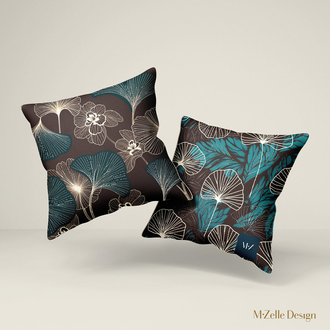 deux Coussins décoratifs style moderne Mzelle design, aux motifs all over feuille de ginkgo délicatement stylisés, fleurs écru sur fond marron foncé.