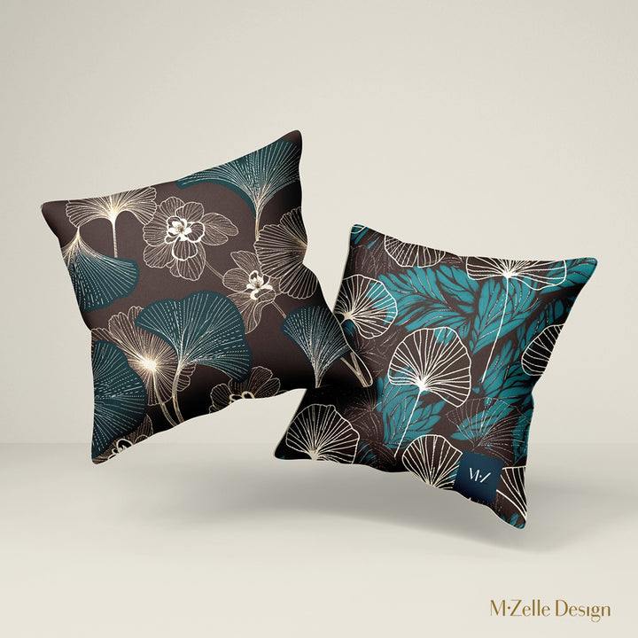 deux Coussins décoratifs style moderne Mzelle design, aux motifs all over feuille de ginkgo délicatement stylisés, fleurs écru sur fond marron foncé.