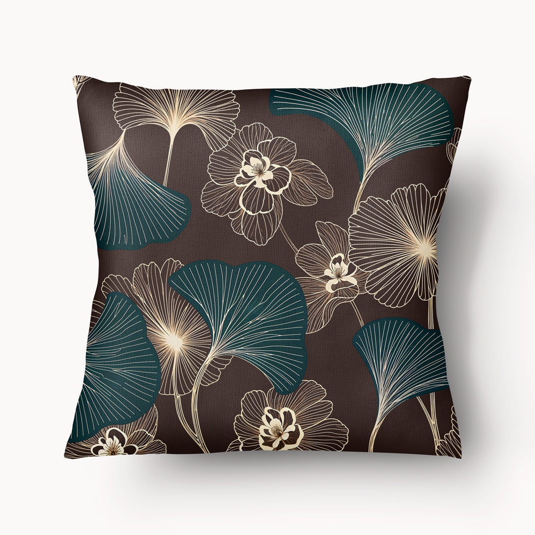 Coussin décoratif style moderne Mzelle design, aux motifs all over feuille de ginkgo délicatement stylisés, fleurs écru sur fond marron foncé.