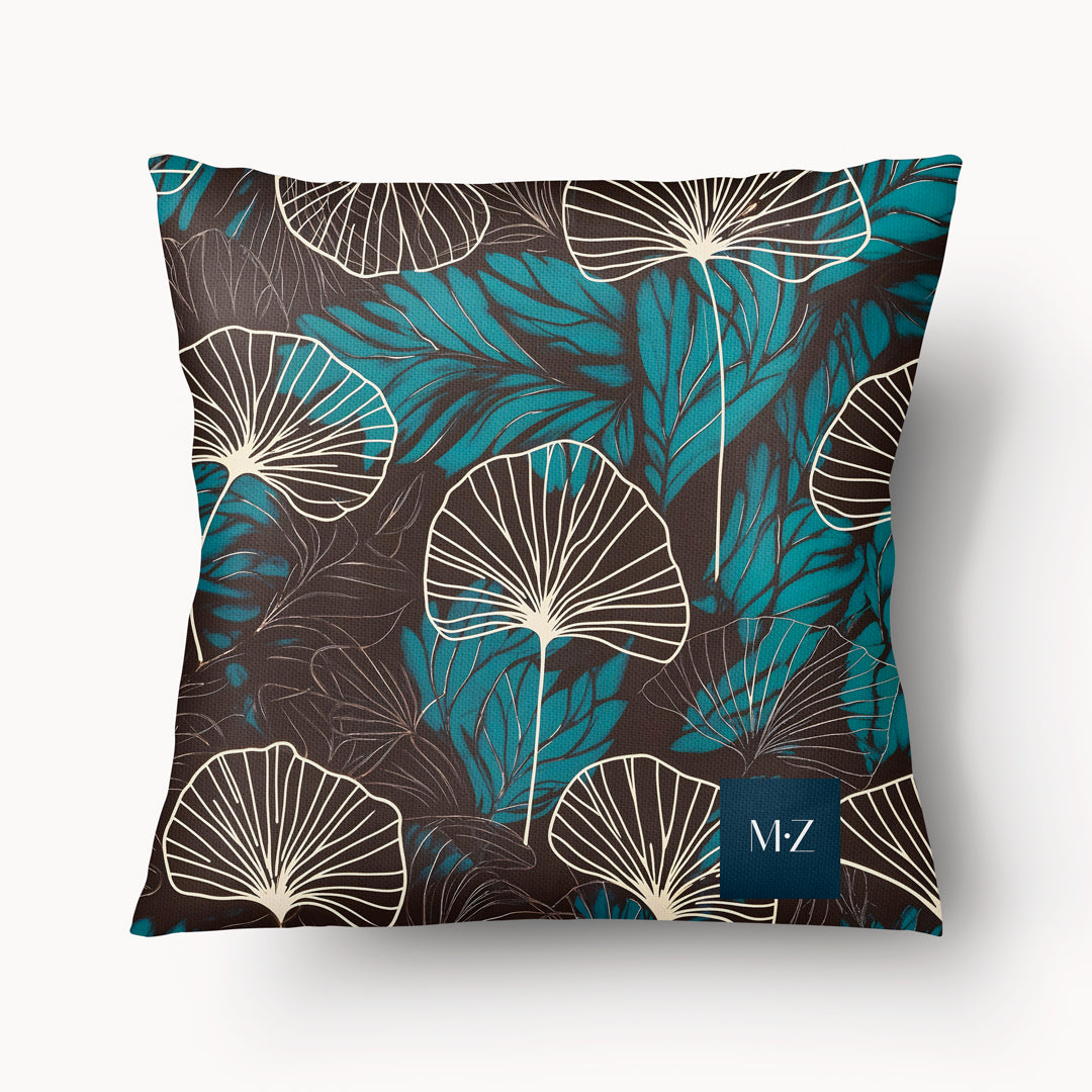 Coussin décoratif style moderne Mzelle design, aux motifs all over feuille de ginkgo délicatement stylisés, fleurs écru sur fond marron foncé.
