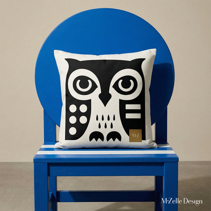 Photographie professionnelle d'un grand coussin motif hibou graphique mzelle design, posé sur une grande chaise en bois peint bleu vif sans accoudoirs, dossier composé d'un large cercle et assise en bois peint rayé bleu et blanc.