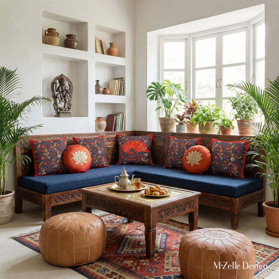 Photographie professionnelle extrêmement détaillée , Villa Riad lumineuse mélange de style nomade berbère et Inde du Sud, vue de face d'un superbe banc, assises de tissu bleu orné de plusieurs coussins motifs indiens mzelle design et de 2 coussins ronds en soie bleu nuit avec un lotus brodé rouge, service à thé marocain et pâtisseries orientales sur la table basse sheesham sculptée.