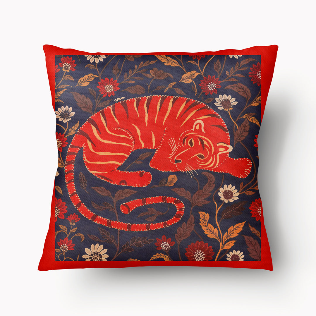 Coussin décoratif carré Mzelle Design imprimé tigre du bengale allongé sur un fond fleuri bleu nuit, ordure orange, style indien raffiné.