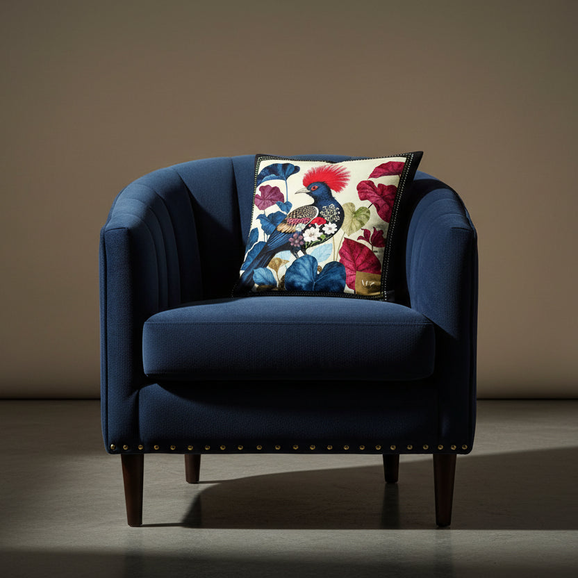 Photographie professionnelle qualité studio, d'un coussin mzelle design disposé sur une chaise crapaud en velours bleu nuit, rivet en laiton, dossier arrondi matelassé, sans accoudoirs, disposée dans un décor neutre beige.