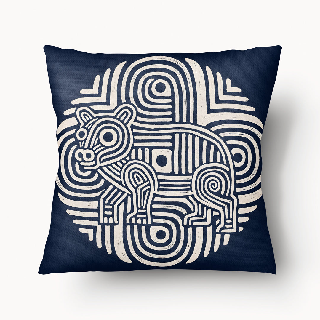 Coussin graphique de décoration de la marque MZelle Design, sur fond bleu  un animal écru sur un motif tribal, style rupestre moderne