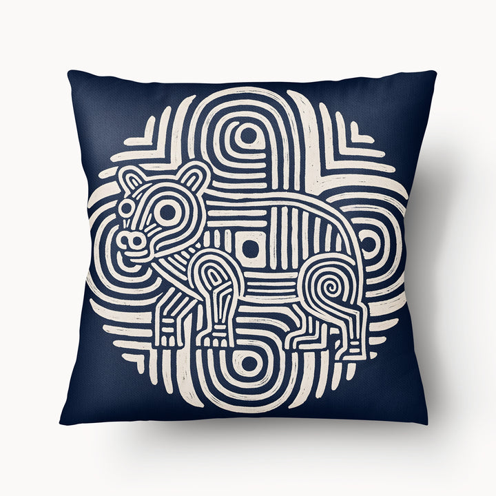 Coussin graphique de décoration de la marque MZelle Design, sur fond bleu  un animal écru sur un motif tribal, style rupestre moderne