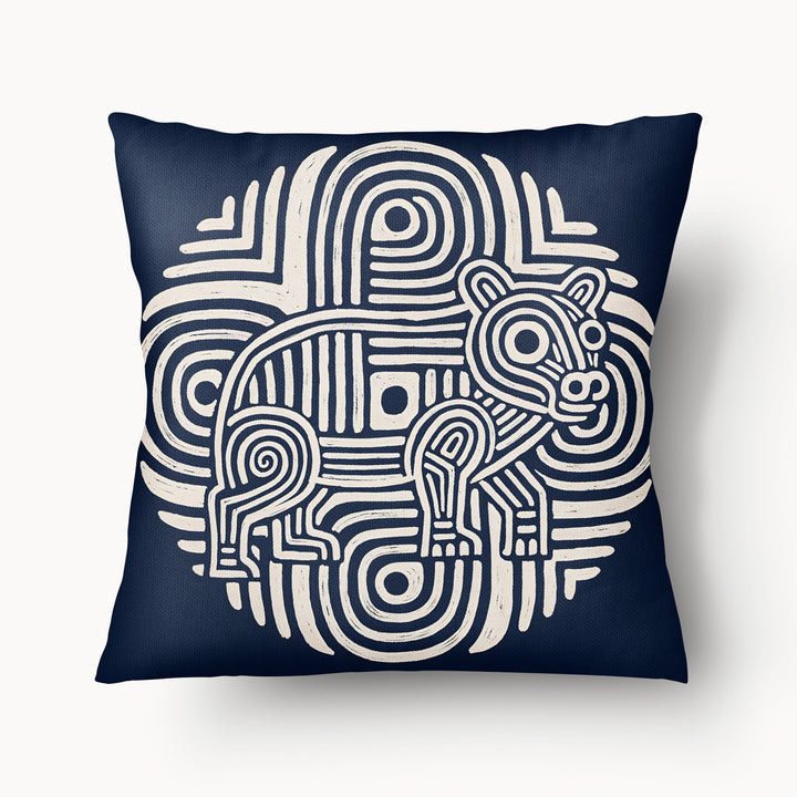 Coussin graphique de décoration de la marque MZelle Design, sur fond bleu  un animal écru sur un motif tribal, style rupestre moderne