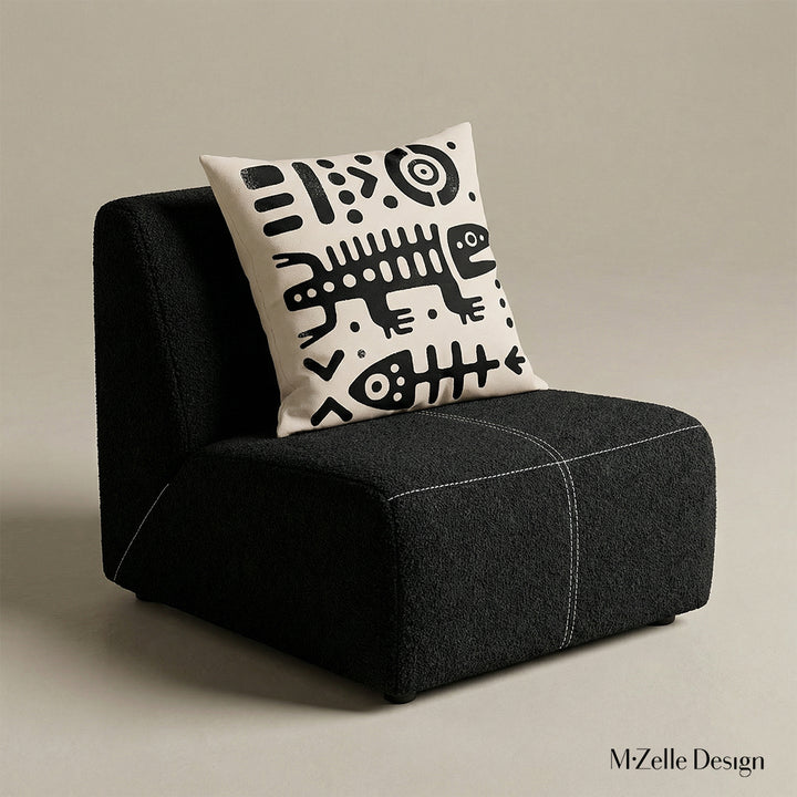 Photographie professionnelle  d'un fauteuil en en tissu laineux texturé noir, sans accoudoirs, assise surpiqué de fil blanc, orné d'un large coussin graphique mzelle design, disposé dans décor écru neutre. 