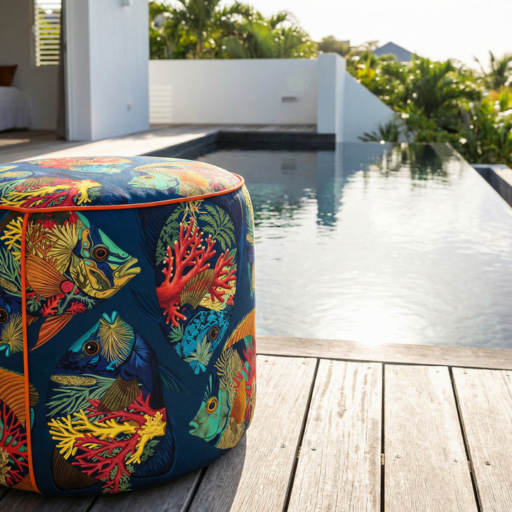 décoration tropicale montrant un pouf au bord d'une piscine, atmosphère chic des Antilles, motifs poissons tropicaux. 