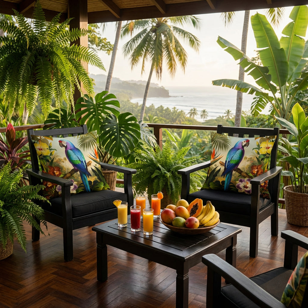 Photographie professionnelle d'une terrasse d'éco-lodge esprit jungle, vue de face en gros plan sur 2 fauteuils en bois noir , orné de 2 larges coussins motif perroquet mzelle design, exposé sur la véranda avec un jardin botanique de fougères et monstera, bananier. Table avec des fruits.