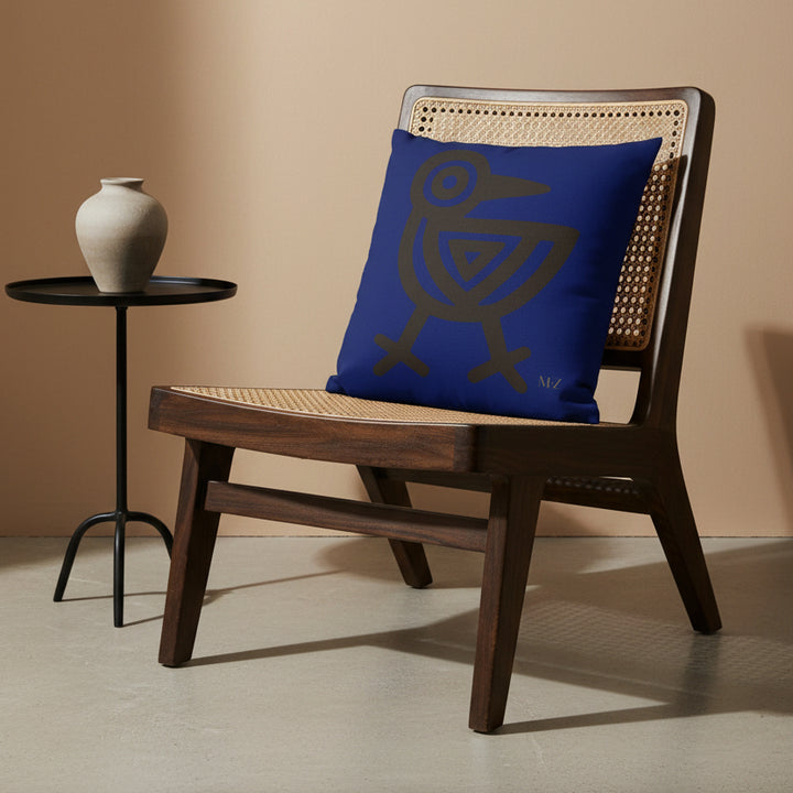 Photographie professionnelle de décoration avec un coussin mzelle design motif tribal, disposé sur un fauteuil afro chic moderne en bois de manguier laqué dans un décor beige neutre.