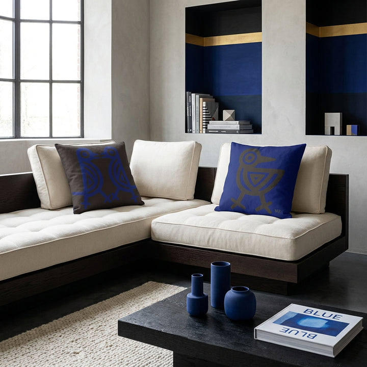 Photo professionnelle lBelgian Minimalism,  grand canapé plateforme d'angle en bois foncé et assises en twill ivoire capitonnés, orné de 2 coussins mzelle design de chaque côté . Murs minéraux texturés en enduit à la chaux et béton ciré gris perle, sublimés par des niches peintes. 