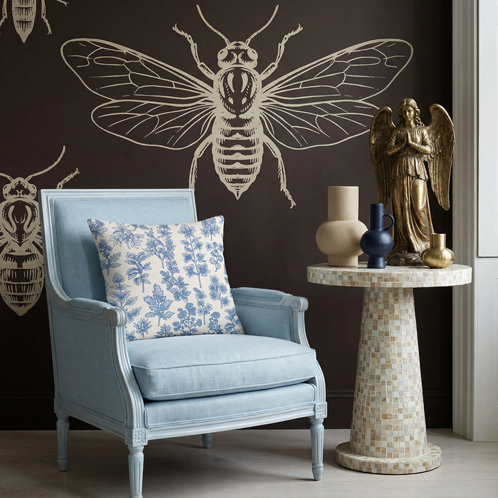 Photographie professionnelle, vue de face d'un fauteuil neo classique en lin bleu lavande au design arrondi audacieux, rehaussée par un large coussin au milieu et deux coussins arrondis en laine écru.