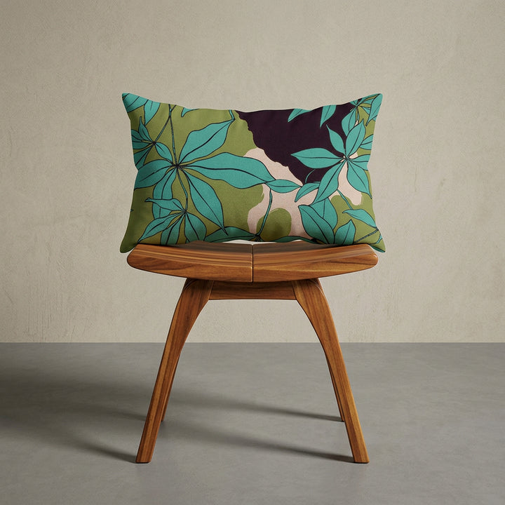 Photographie professionnelle extrêmement détaillée et de haute qualité d'un coussin mzelle design motif stylisé feuilles eucalyptus, disposé sur un tabouret japonais moderne en bois d'acacia vernis disposé contre un mur, dans un décor beige neutre, sobre, sol en ciment couleur neutre.