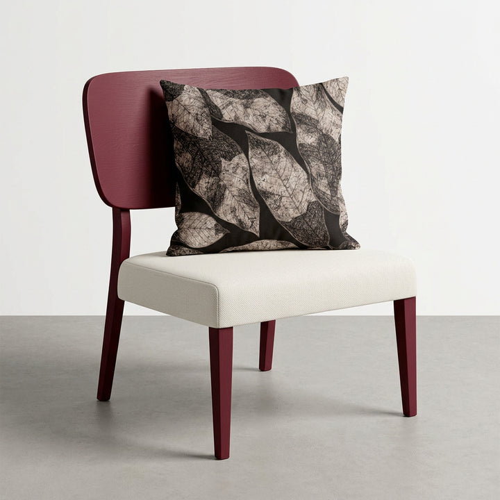 Photographie d'un grand coussin carré mzelle design motif graphique feuilles, disposé sur un fauteuil moderne en bois disposé sur un fond neutre, qualité studio photo.