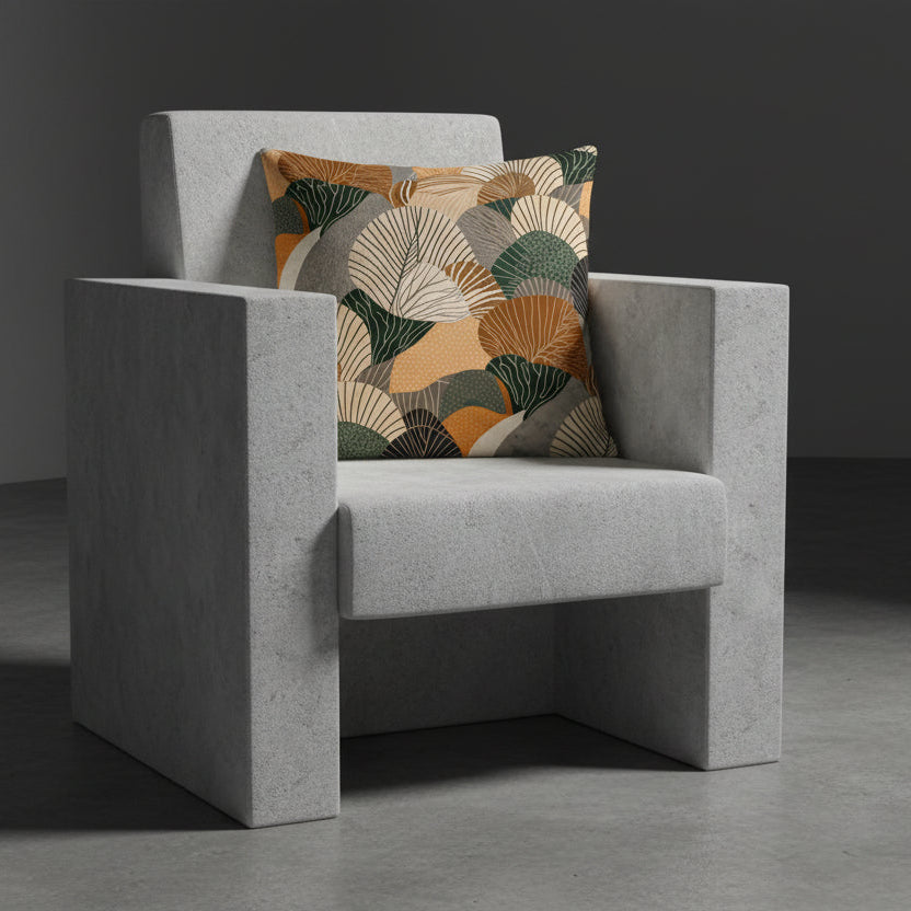Photographie professionnelle qualité studio, extrêmement détaillée et de haute qualité d'un coussin mzelle design disposé sur un fauteuil gris clair au design brutaliste  disposé dans décor gris foncé, sobre, sol en ciment foncé. 