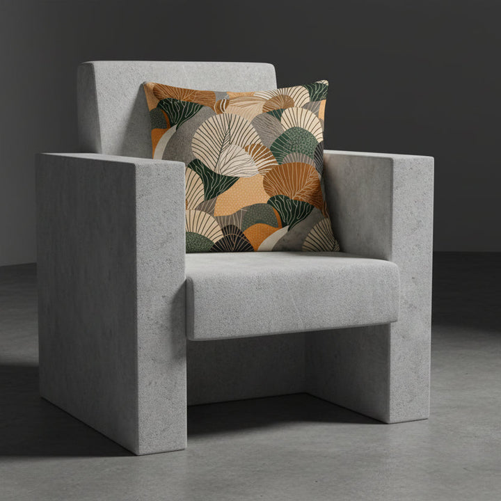 Photographie professionnelle qualité studio, extrêmement détaillée et de haute qualité d'un coussin mzelle design disposé sur un fauteuil gris clair au design brutaliste  disposé dans décor gris foncé, sobre, sol en ciment foncé. 