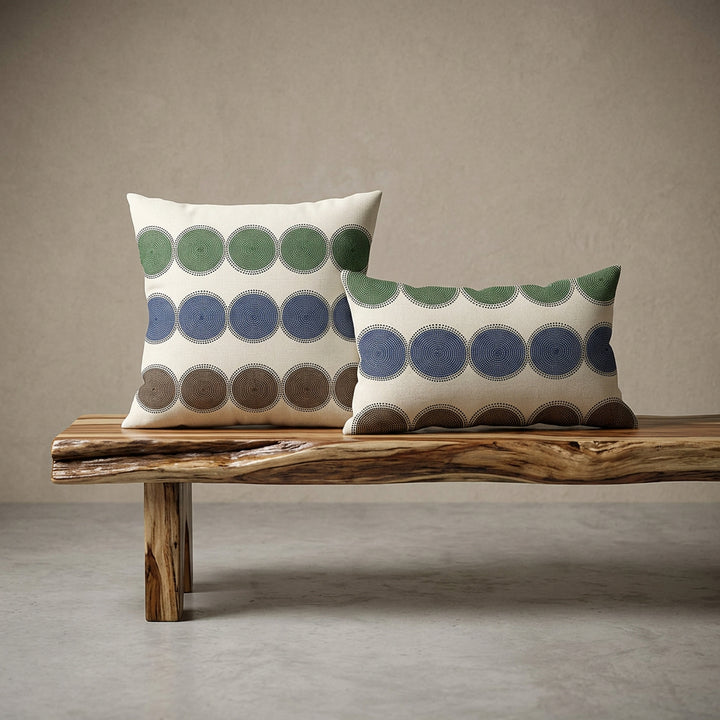 Photographie professionnelle de haute qualité de deux coussins coordonnés mzelle design, sur une banquette de bois flotté vernis disposé contre un mur, dans un décor beige neutre, sobre, sol en ciment couleur unie.