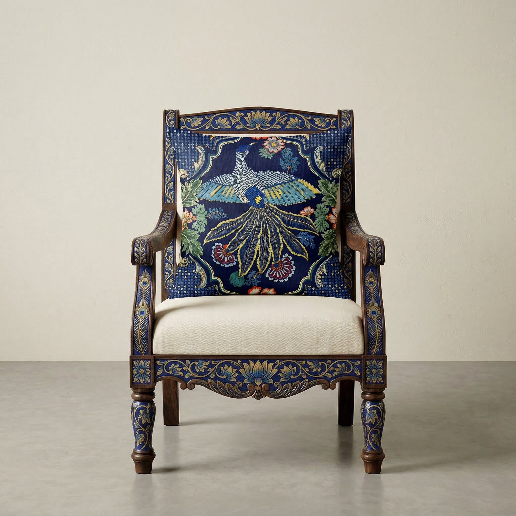 Photographie professionnelle de décoration, montrant un superbe fauteuil Indien Style dravidien, assise en coton écru, structure en bois de manguier peint à la main de motifs floraux Indien bleu vif et doré, orné d'un large coussin motif oiseau mzelle design et disposé dans décor écru neutre.