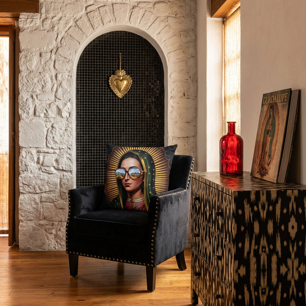 Photographie professionnel décoration intérieure de loft mexicain, vue de face d'une chaise en velours noir finitions rivets laiton design moderne, orné d'un large coussin mzelle design motif vierge marie, placé devant une niche en arche de mosaiques noir dans le mur en pierres blanchies, décoré d'un EX VOTO en laiton, commode peinte.