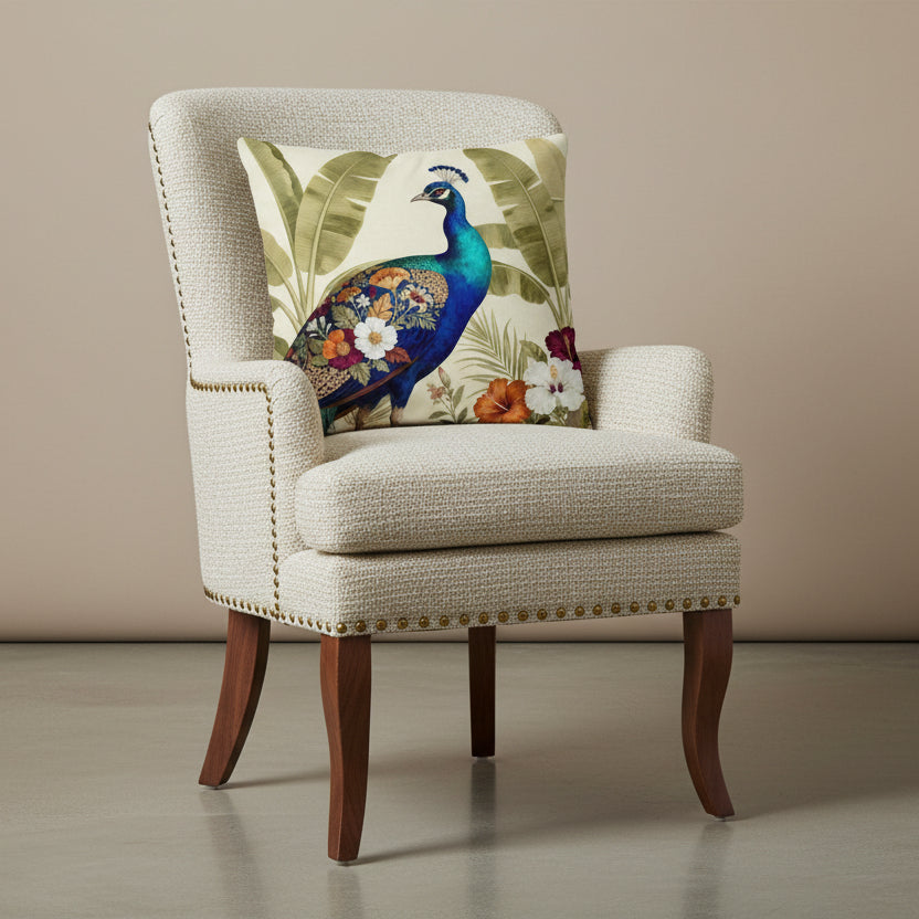 Photographie professionnelle qualité studio, extrêmement détaillée et de haute qualité d'un coussin mzelle design motif paon bleu, disposé sur un fauteuil crapaud en tweed écru, rivet en laiton, bois de noyer, sans accoudoirs, disposée dans un décor neutre beige