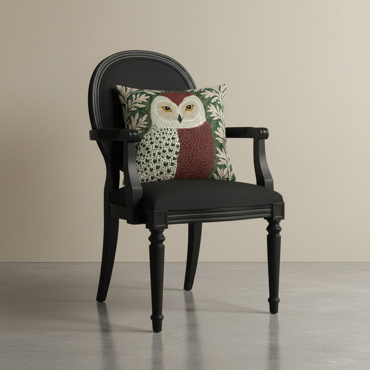 photographie professionnelle studio, vue de 3/4 sur un fauteuil régence noir avec un coussin mzelle design motif chouette vintage posé dessus, placé dans un décor beige neutre et sol en béton ciré.