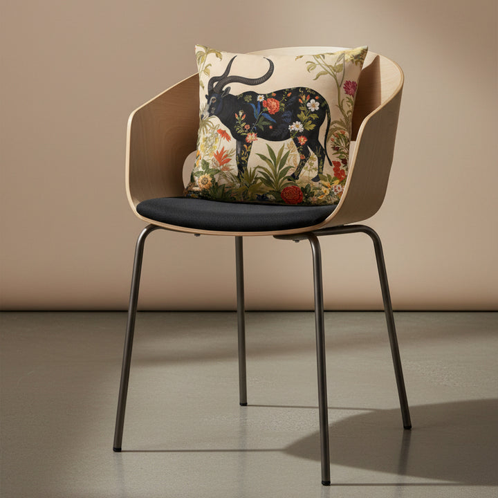 photographie professionnelle studio, vue de 3/4 sur une chaise haute design moderne dossier arrondie, assise en twill noir avec un coussin mzelle design motif buffle,  posé dessus, placé dans un décor beige neutre et sol en béton ciré.