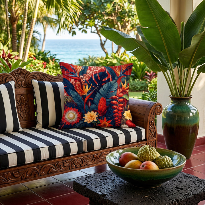 Photographie professionnelle décoration terrasse de villa Palm Beach,  canapé en bois noir, structure sculptée épaisse et assises à rayures noir et blanc, orné d'un grand coussin mzelle design motif tropical,  jardin tropicalisé vue océan, sol carrelé rouge grenat, table basse en roche volcanique.