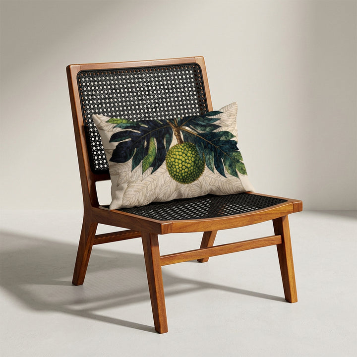 Photographie d'un grand coussin rectangle mzelle design motif fruit tropical disposé sur un fauteuil de style créole, en bois précieux disposé sur un fond neutre, qualité studio photo. 