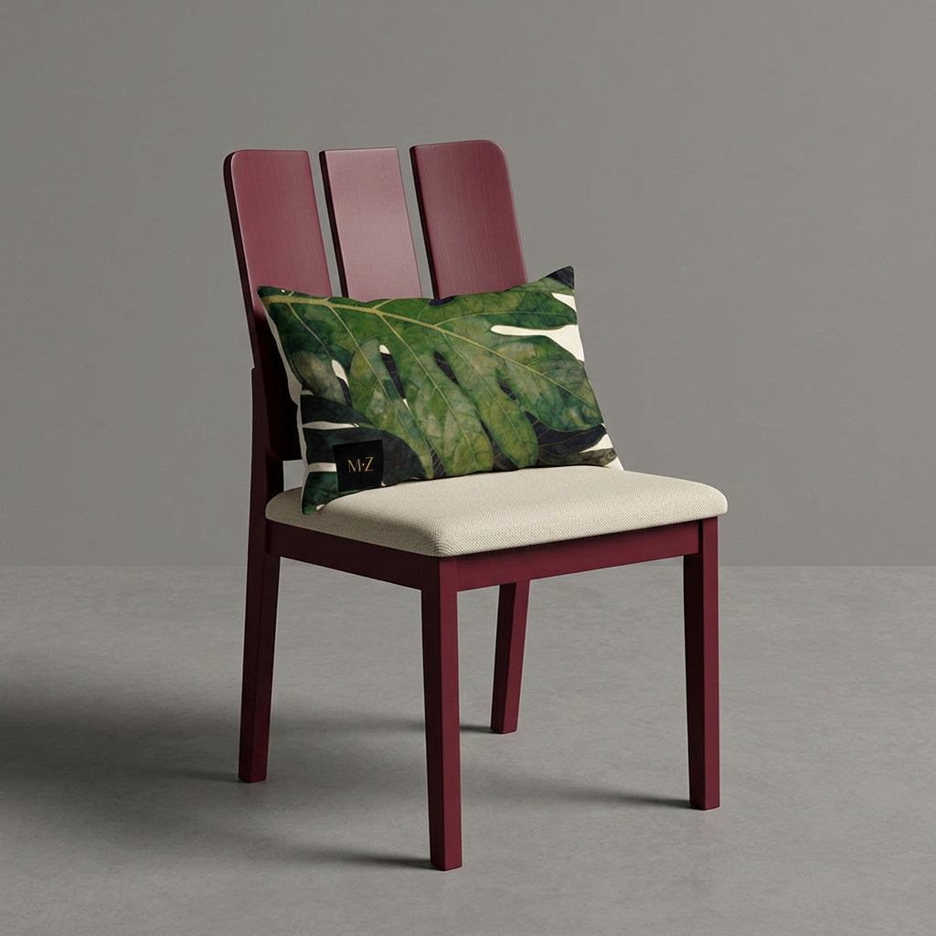 Photographie d'un grand coussin rectangle mzelle design motif fruit tropical disposé sur un fauteuil de style créole, en bois précieux disposé sur un fond neutre, qualité studio photo. 