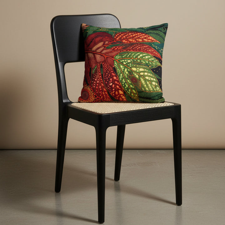 photographie professionnelle studio, vue de 3/4 sur une chaise créole haute en bois de wengé noir, design moderne dossier arrondie, assise en cannage écru avec un coussin mzelle design motif fruit à pain rouge, posé dessus, placé dans un décor beige neutre.