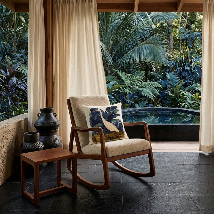 Photo professionnelle lifestyle, décoration terrasse d’eco-lodge du costa-rica,  rocking chair moderne bois de mahogany orné d'un coussin mzelle design motif oiseau, table basse assortie, sol en carrelage noir, poteries artisanales empilées de façon artistique dans un muret , rideaux en lin crème flottant , architecture ouverte sur une jungle luxuriante et piscine sombre moderne.