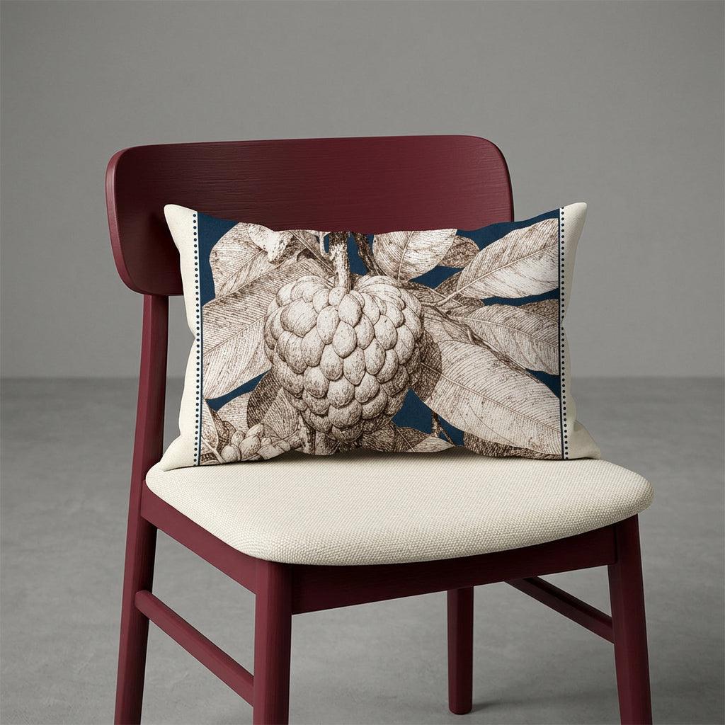 Photographie d'un grand coussin carré mzelle design motif fruit tropical attier, disposé sur un fauteuil de style créole, en bois précieux disposé sur un fond neutre, qualité studio photo. 