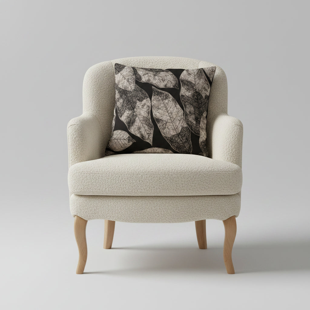 Photographie qualité studio,  d'un grand coussin carré mzelle design disposé sur un fauteuil crapaud en bois clair et assise de laine bouclée écrue, disposé sur un fond neutre.