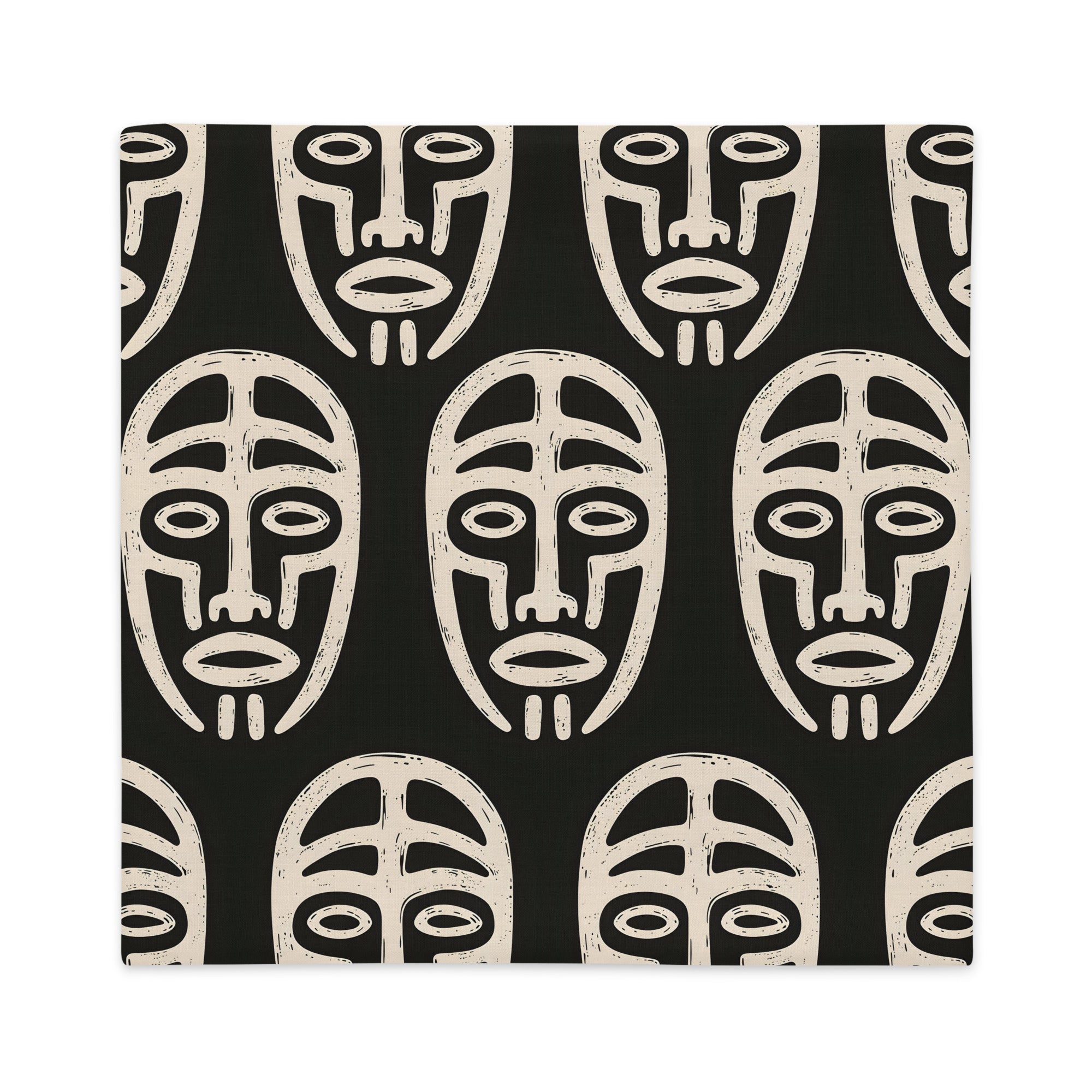 Coussin graphique de décoration de la marque MZelle Design, sur fond noir un motif beige représente un masque tribal, style rupestre moderne