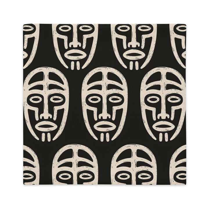 Coussin graphique de décoration de la marque MZelle Design, sur fond noir un motif beige représente un masque tribal, style rupestre moderne