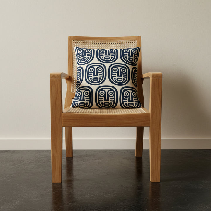 Photographie professionnelle qualité studio, d'un grand coussin mzelle design disposé sur un fauteuil créole en bois de manguier sans accoudoirs, dossier en cannage beige, structure épaisse, disposé dans décor écru neutre.