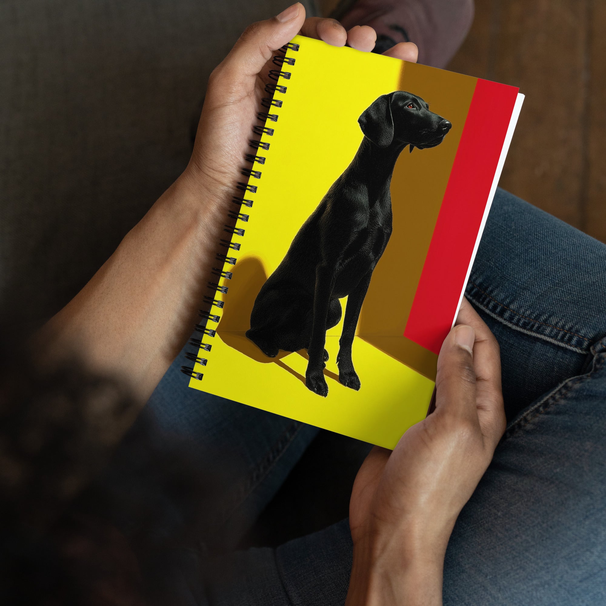 Carnet A5 Illustré par West Kast, met en scène  un grand chien noir attentif et un chat espiègle à l'affût dans des tons jaune vif et rouge